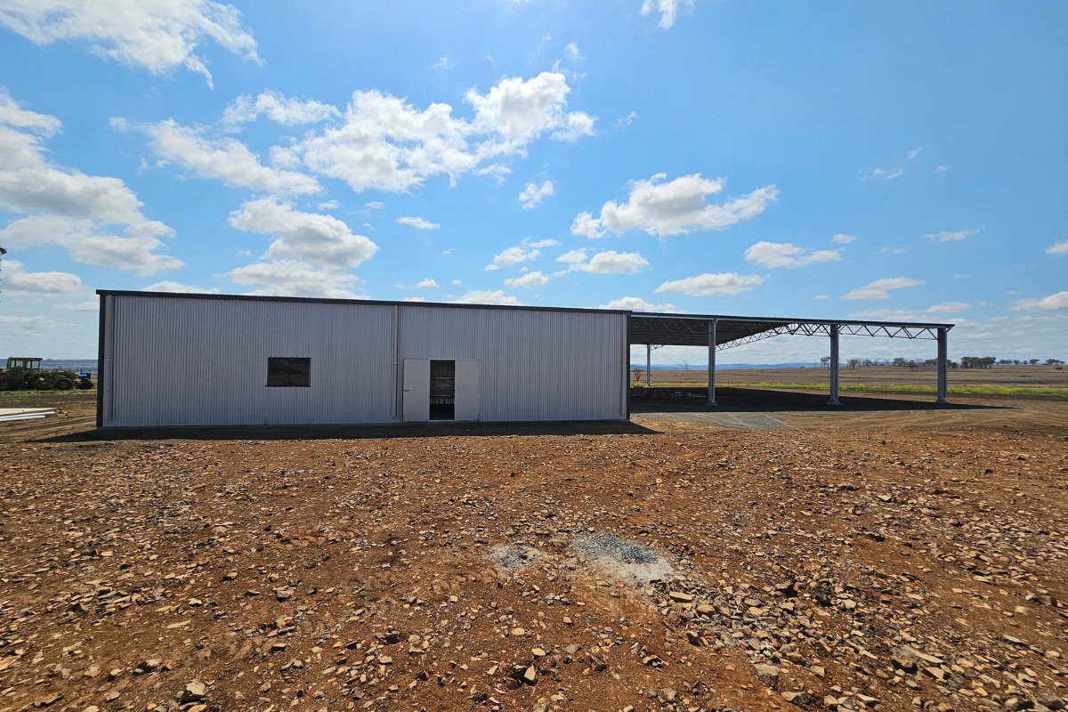 Combination shed with yard cover and enclosed bay